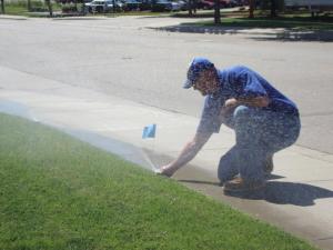 a Plantation sprinkler repair professional is adjusting a sprinkler head